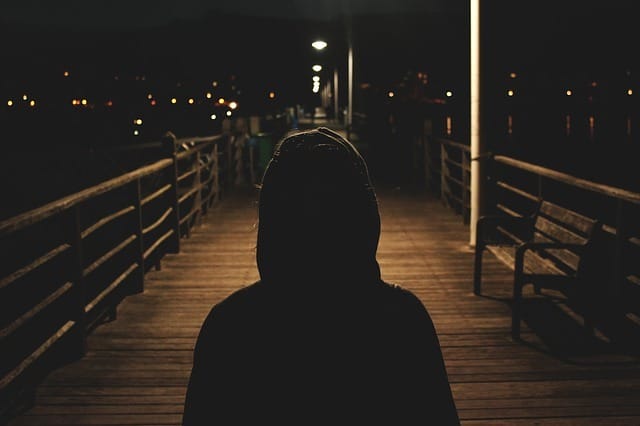 Photo of a hooded person in the dark